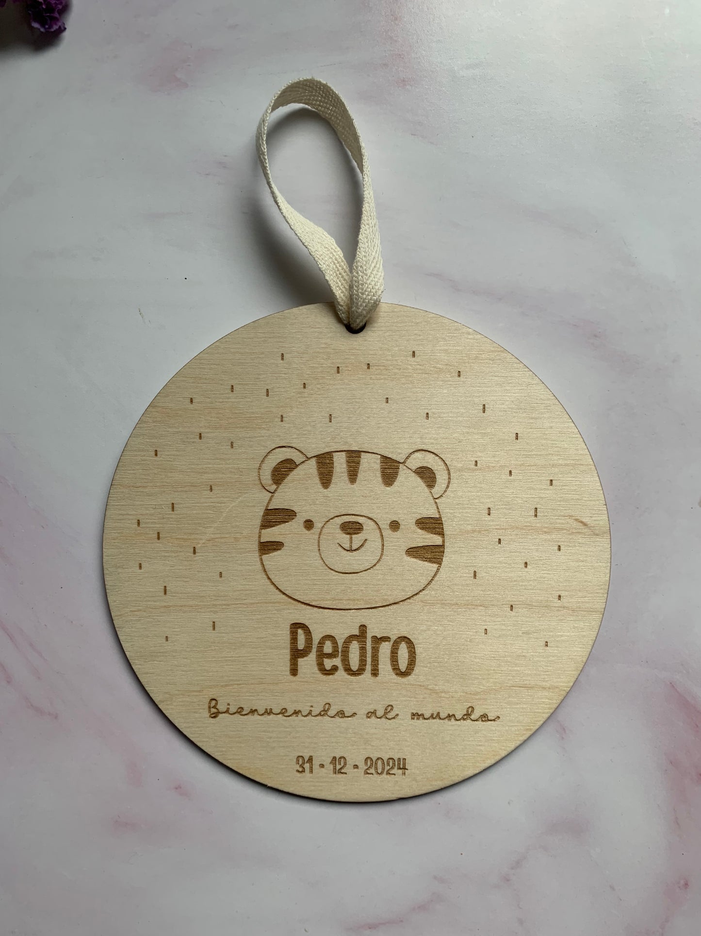 Placa de nacimiento de madera con datos del bebé sobre un fondo claro