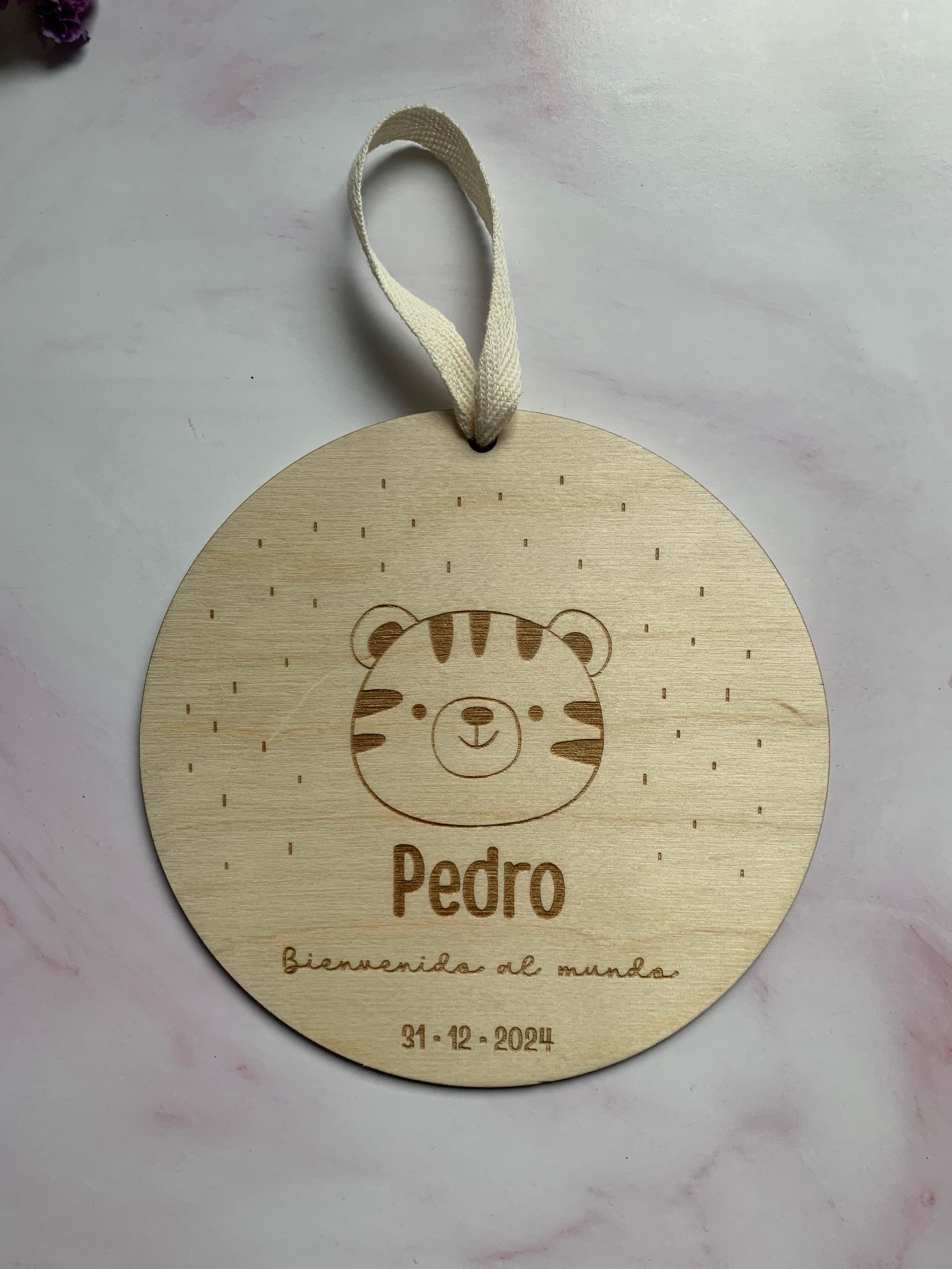 Placa de nacimiento de madera con datos del bebé sobre un fondo claro