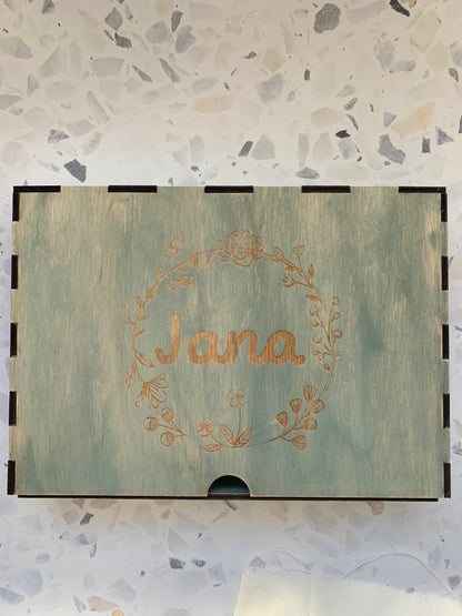 Cajón de madera personalizado para recuerdos, colocado en un ambiente acogedor, resaltando la calidad del grabado y la madera.