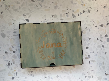 Cajón de madera personalizado para recuerdos, colocado en un ambiente acogedor, resaltando la calidad del grabado y la madera.