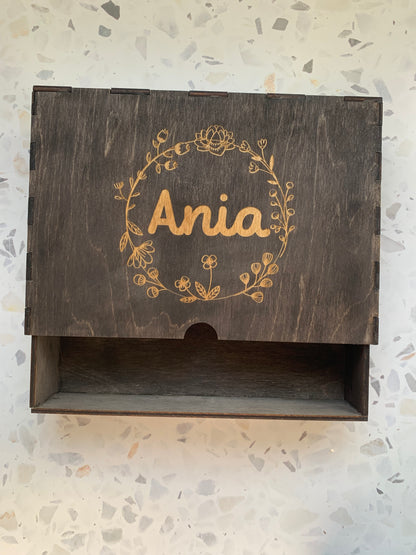 Cajón de madera para recuerdos abierto, revelando su interior y sugerencias de objetos personales como fotos o chupetes.