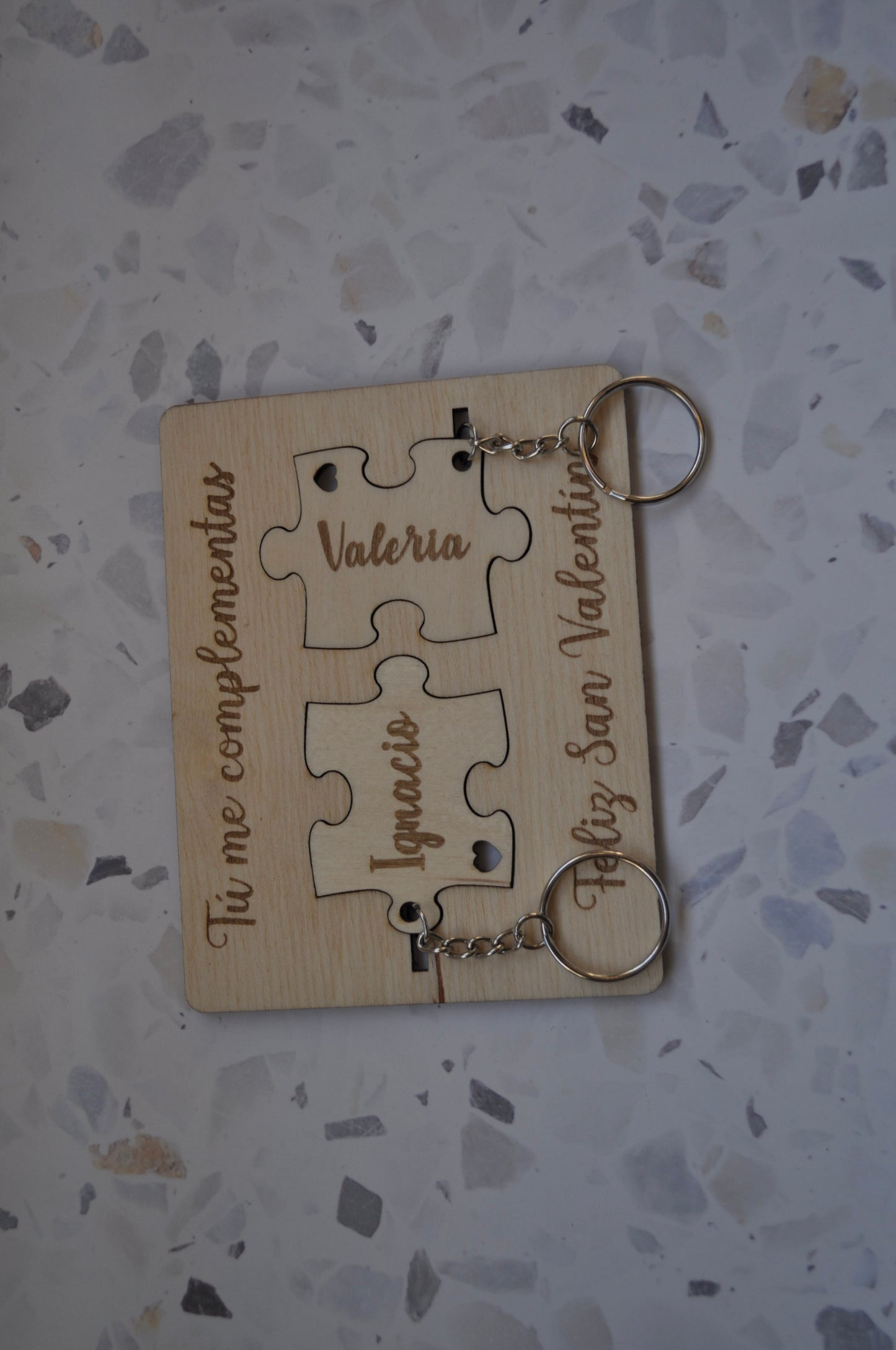 Llavero puzzle de madera personalizado, mostrando las dos piezas encajadas con un nombre grabado.