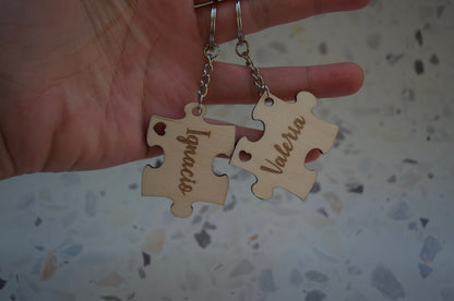 Llavero puzzle de madera personalizado con un nombre, colgado junto a unas llaves, demostrando su tamaño y cómo se ve en uso.