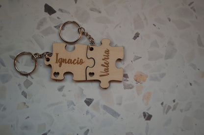 Dos piezas separadas de un llavero puzzle de madera personalizado, mostrando los detalles del grabado del nombre y el diseño único.