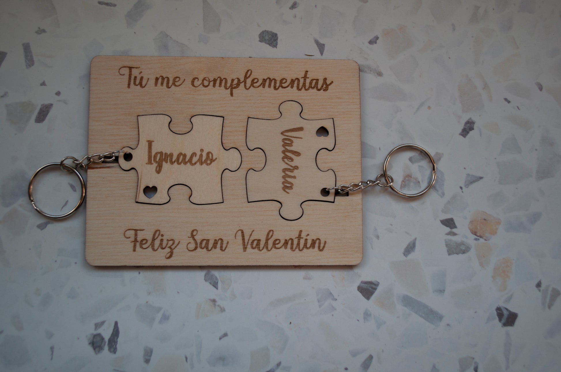 Llavero puzzle de madera personalizado, mostrando las dos piezas encajadas con un nombre grabado.