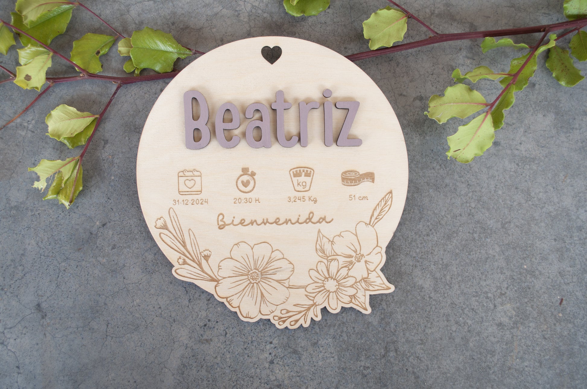 Detalle de nombre personalizado grabado en placa de madera artesanal