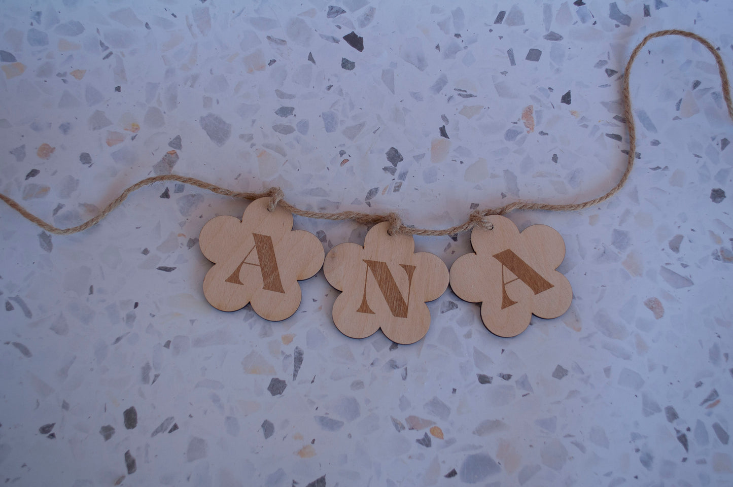 Detalle de las letras y figuras de madera de una guirnalda personalizada, mostrando la calidad del corte y el acabado.