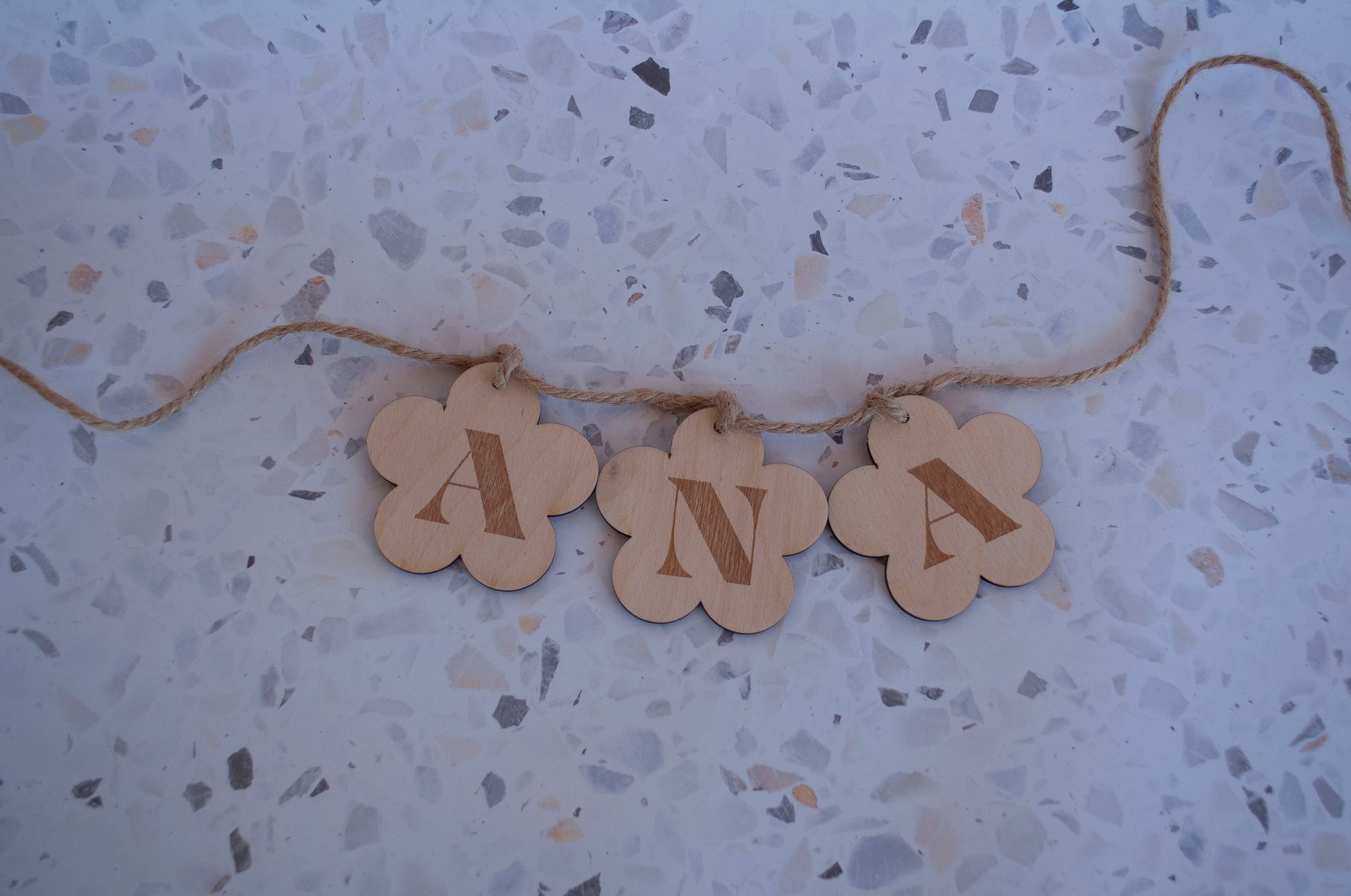 Detalle de las letras y figuras de madera de una guirnalda personalizada, mostrando la calidad del corte y el acabado.