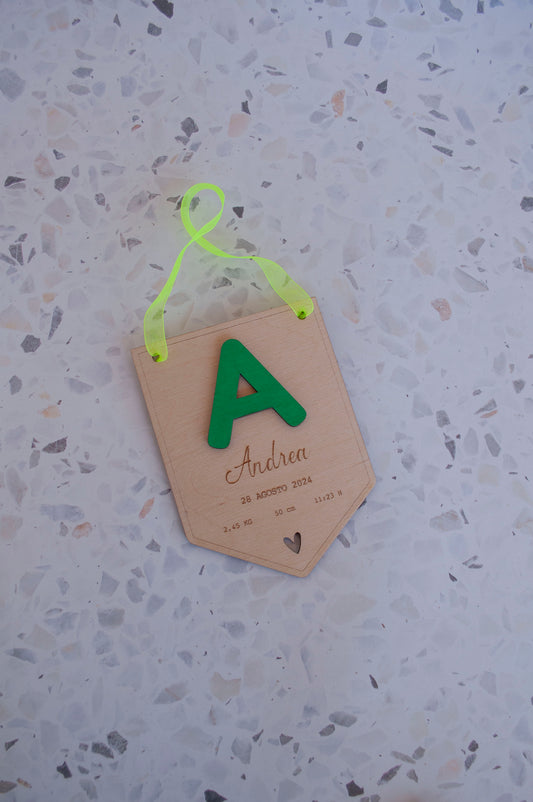 Banderín de madera con inicial verde y cinta para colgar
