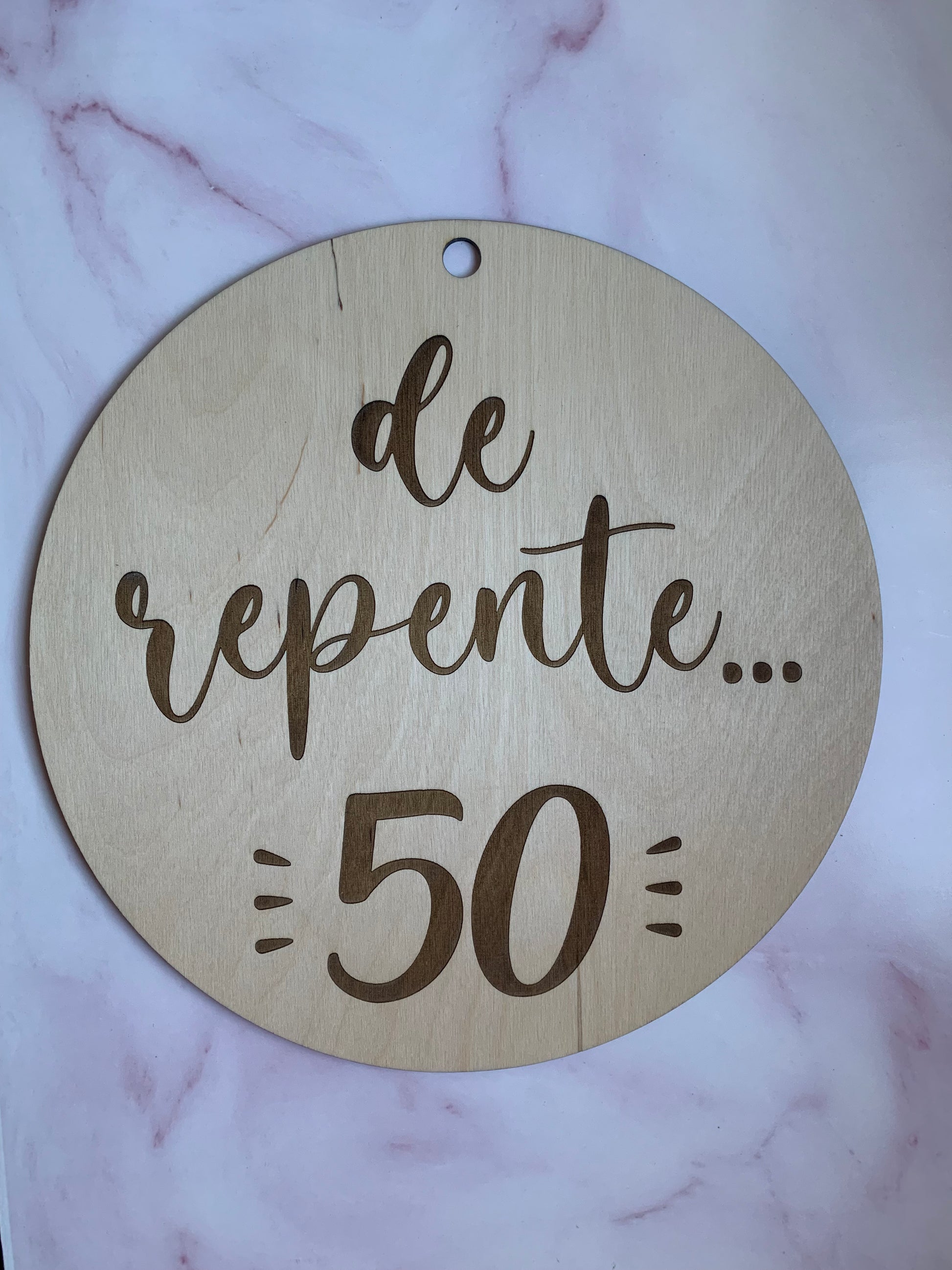 Variedad de fuentes de texto disponibles para grabar en el círculo de madera personalizable, mostrando detalles del grabado.