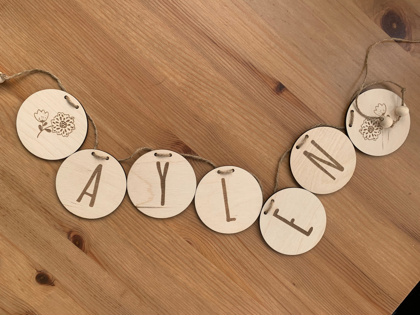 Guirnalda de madera personalizada en diferentes combinaciones de colores y diseños, demostrando las opciones de personalización.