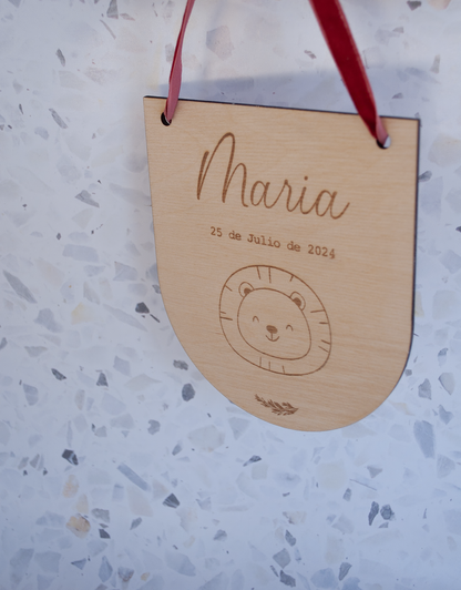 Decoración habitación bebé con placa de nombre en madera natural colgada en pared infantil

