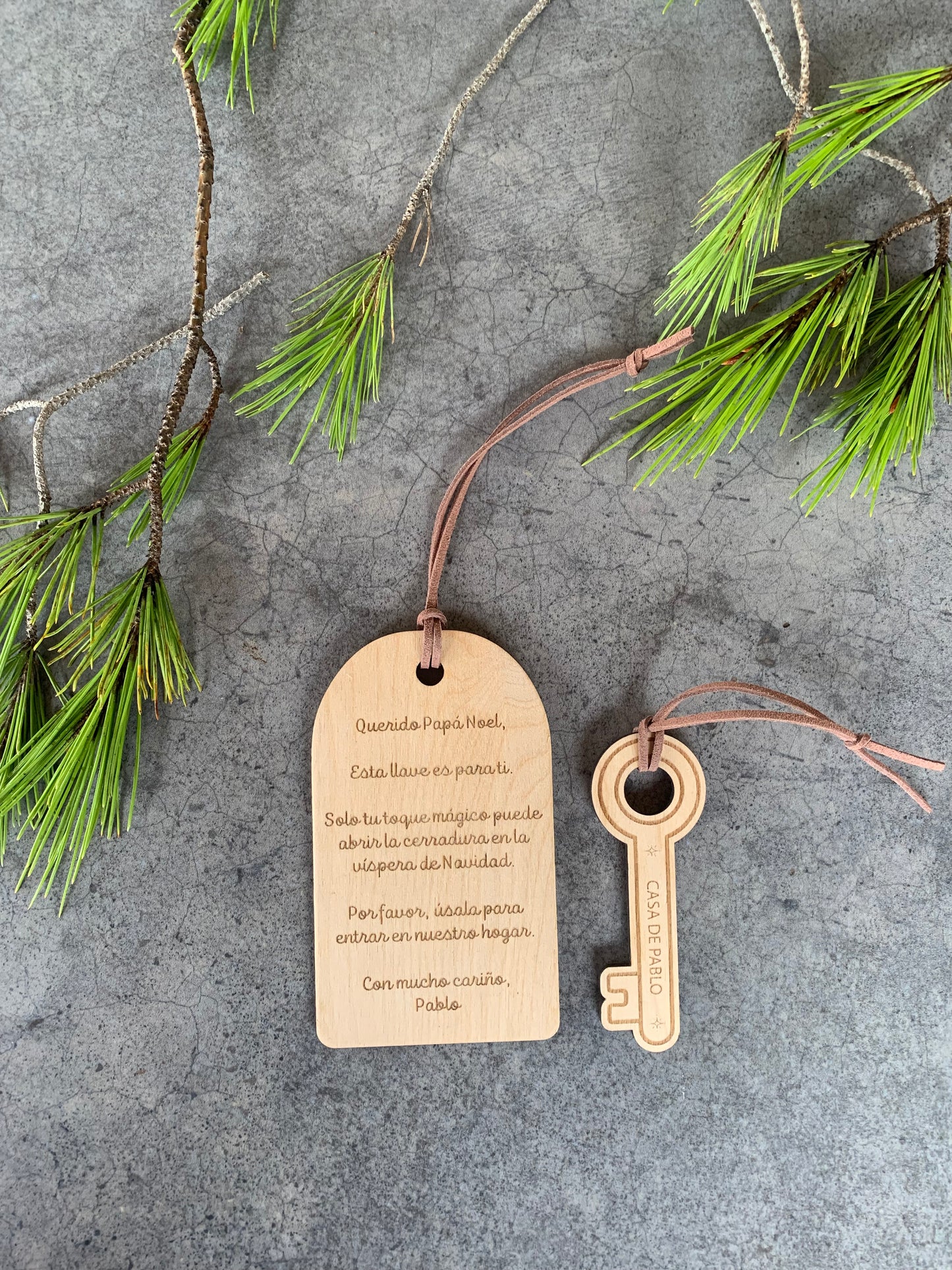 Detalle de llave navideña artesanal en madera con grabado láser de Papá Noel y cuerda marrón