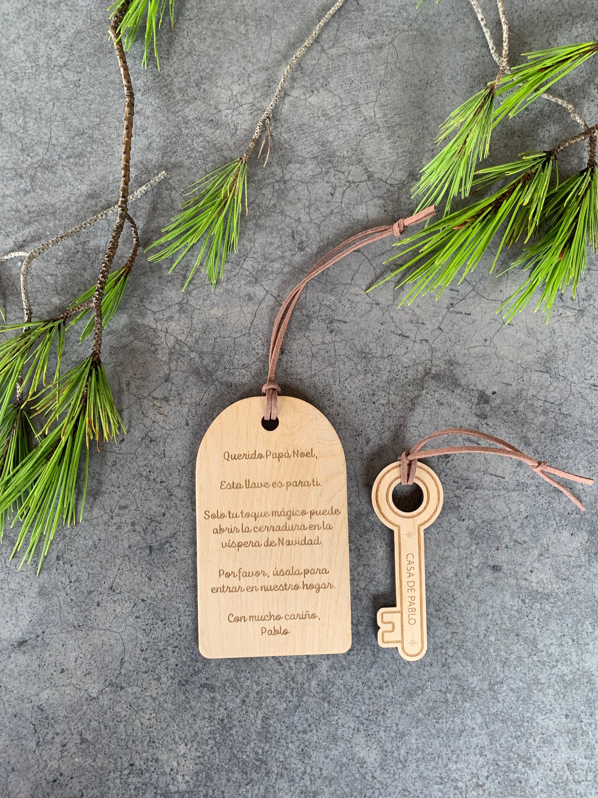 Detalle de llave navideña artesanal en madera con grabado láser de Papá Noel y cuerda marrón