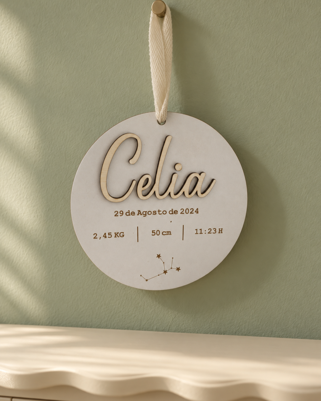 Placa de nacimiento personalizada con zodiaco en MDF blanco colgada en pared verde salvia